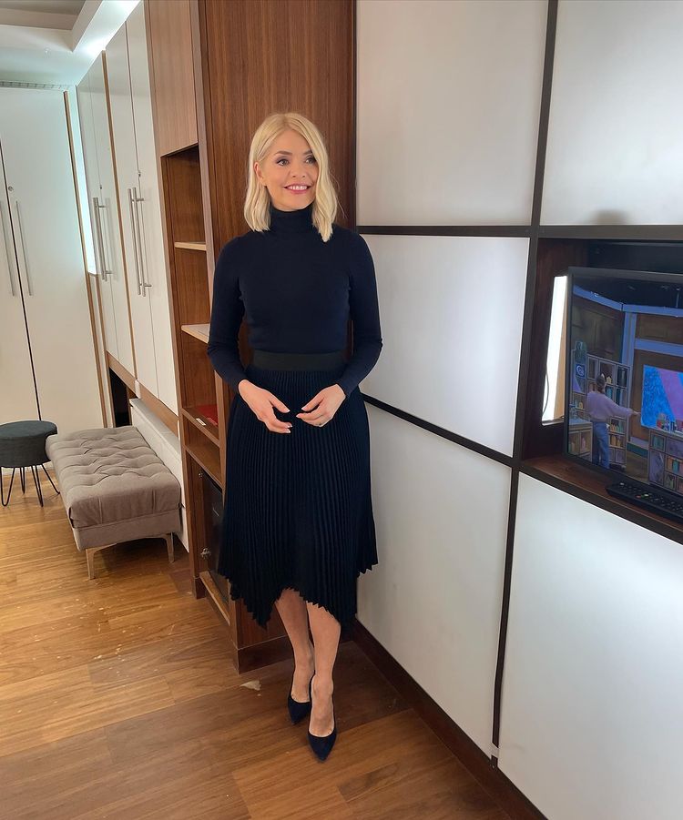 where to get all Holly Willoughby This Morning outfits navy pleated skirt navy polo neck navy suede court shoes 10 March 2021 Photo Holly Willoughby
