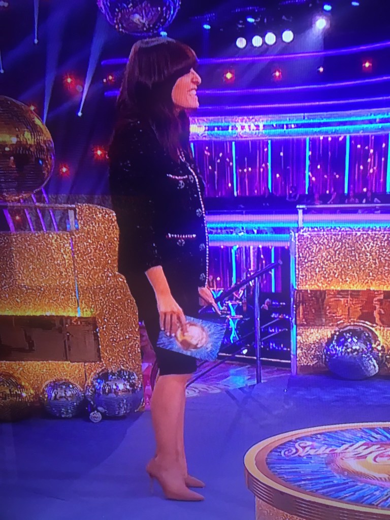 where to get all Claudia Winkleman Strictly Come Dancing outfits metallic embellished black cardigan black skirt nude suede court shoes 10 October 2021 Photo BBC v2
