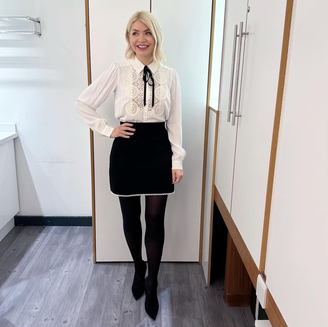 where to get all Holly Willoughby This Morning outfits black pearl trimmed skirt white lace front blouse with black ribbon black suede court shoes 28 February 2023 Photo Holly Willoughby