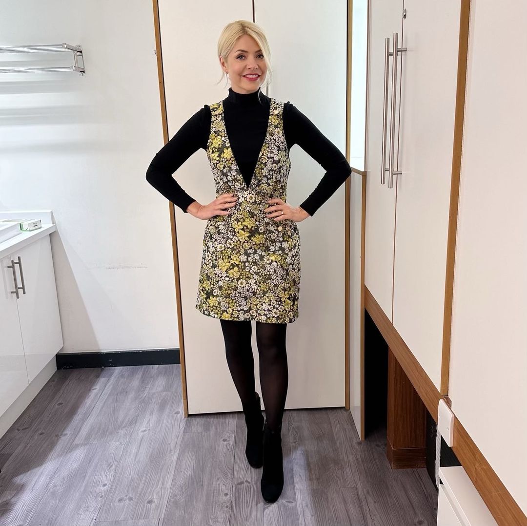 where to get all Holly Willoughby This Morning outfits dresses yellow and white jacquard floral pinafore dress black roll neck jumper black ankle boots 23 February 2023 Photo Holly Willoughby