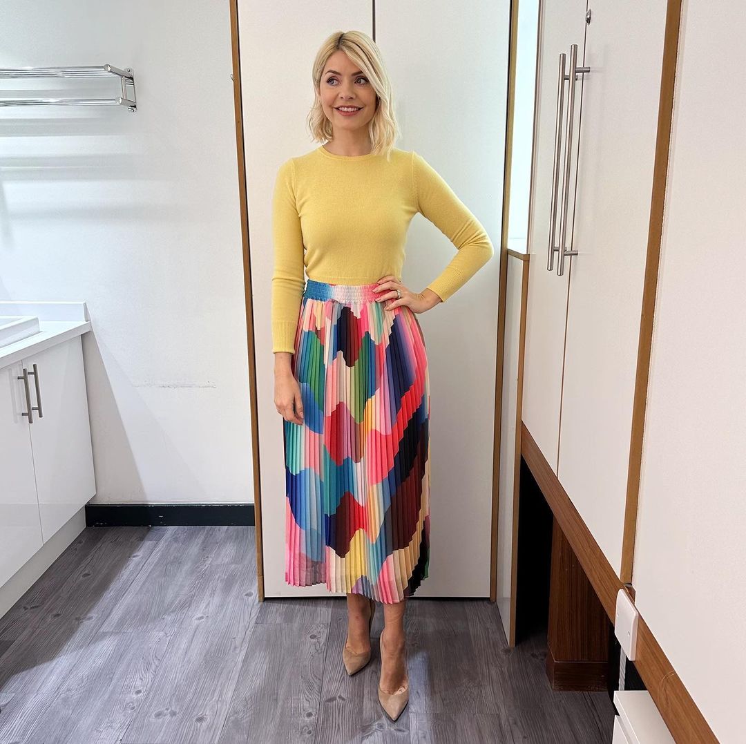 where to get all Holly Willoughby This Morning outfits multi colour graphic pleated skirt yellow crew neck jumper nude suede court shoes 6 March 2023 Photo Holly Willoughby