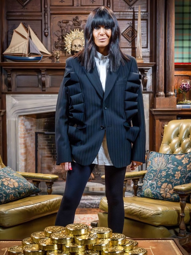 where to get all Claudia Winkleman Celebrity Traitors outfits black pinstripe ruffles blazer black brogues 6 November 2025 Photo BBC Studio Lambert