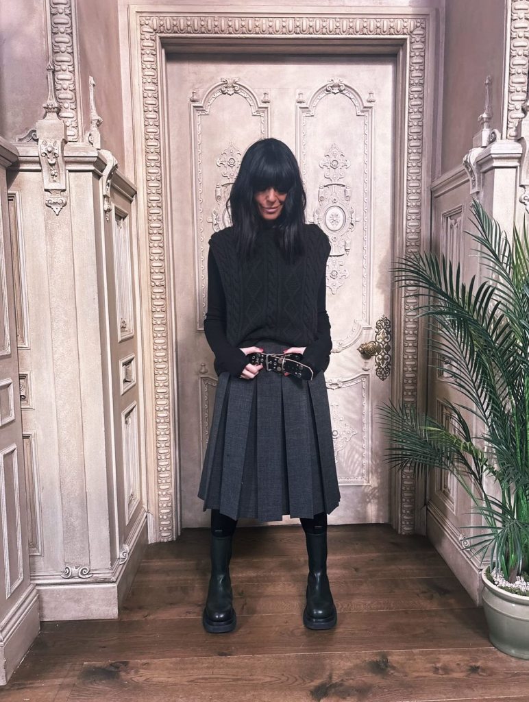where to get all Claudia Winkleman Celebrity Traitors outfits grey skirt brown coat black ankle boots grey cable knit  22 October 2025 Photo Sinead McKeefry