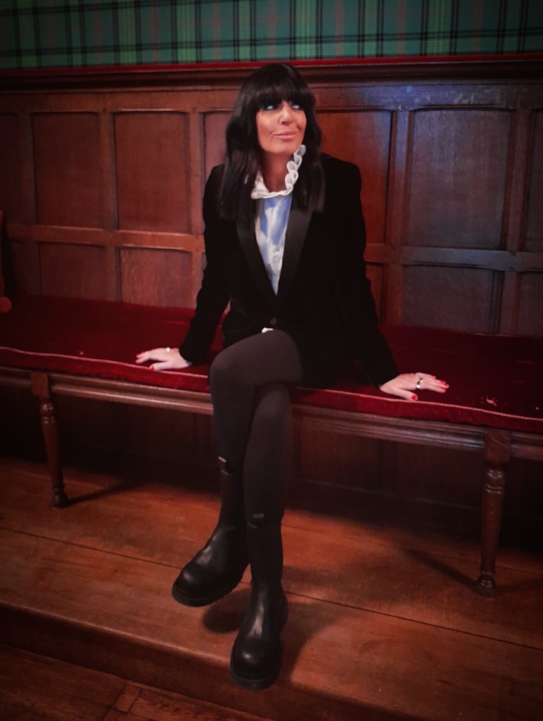 where to get all Claudia Winkleman The Traitors outfits black velvet blazer white pie crust blouse black boots what is Claudia wearing 2 January 2026 Photo Sinead McKeefry
